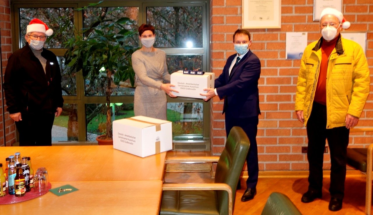 Die Weihnachtspakete bereiten in Weiden Freude. Von links: James P. Federline, Sabine Dippold, Oberbürgermeister Jens Meyer und Helmuth Wächter. Bild: Stadt Weiden. 