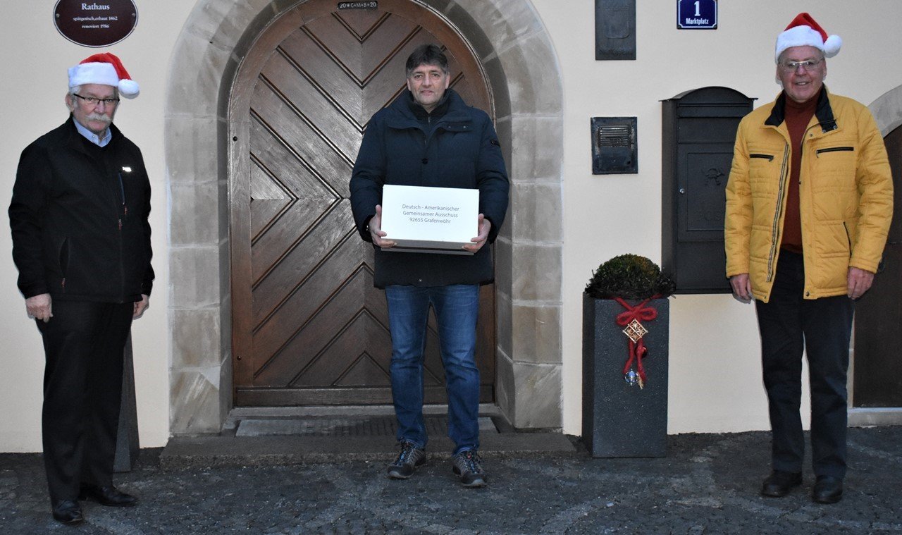 James P. Federline, Grafenwöhrs Bürgermeister Edgar Knobloch und Helmuth Wächter freuen sich, dass auch ohne das Deutsch-Amerikanische Volksfest die Weihnachtsaktion für bedürftige Menschen stattfinden kann. Bild: Renate Gradl. 