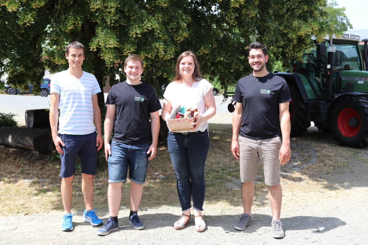 Gruppenbild Gewinnübergabe Bauernmarkt-Quiz. Von Links: Lehrkraft Mathias Beutner, Studierender Valentin Schmidkonz, Gewinnerin Tanja Höllerl, Studierender Mathias Schmeller. Foto: Judith Zeitler